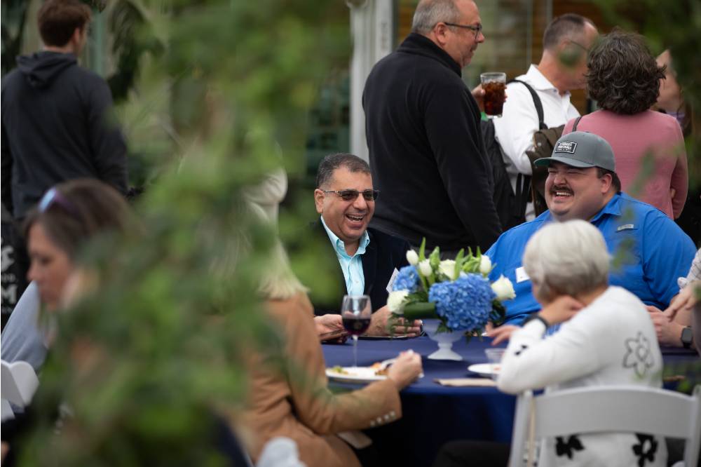 Table of faculty and staff in conversation and laughing